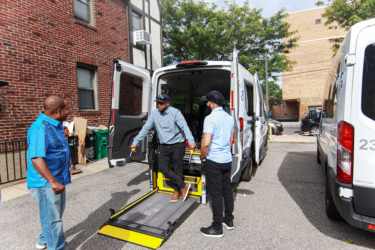 Three men talking beside an ambulance with the rear door open