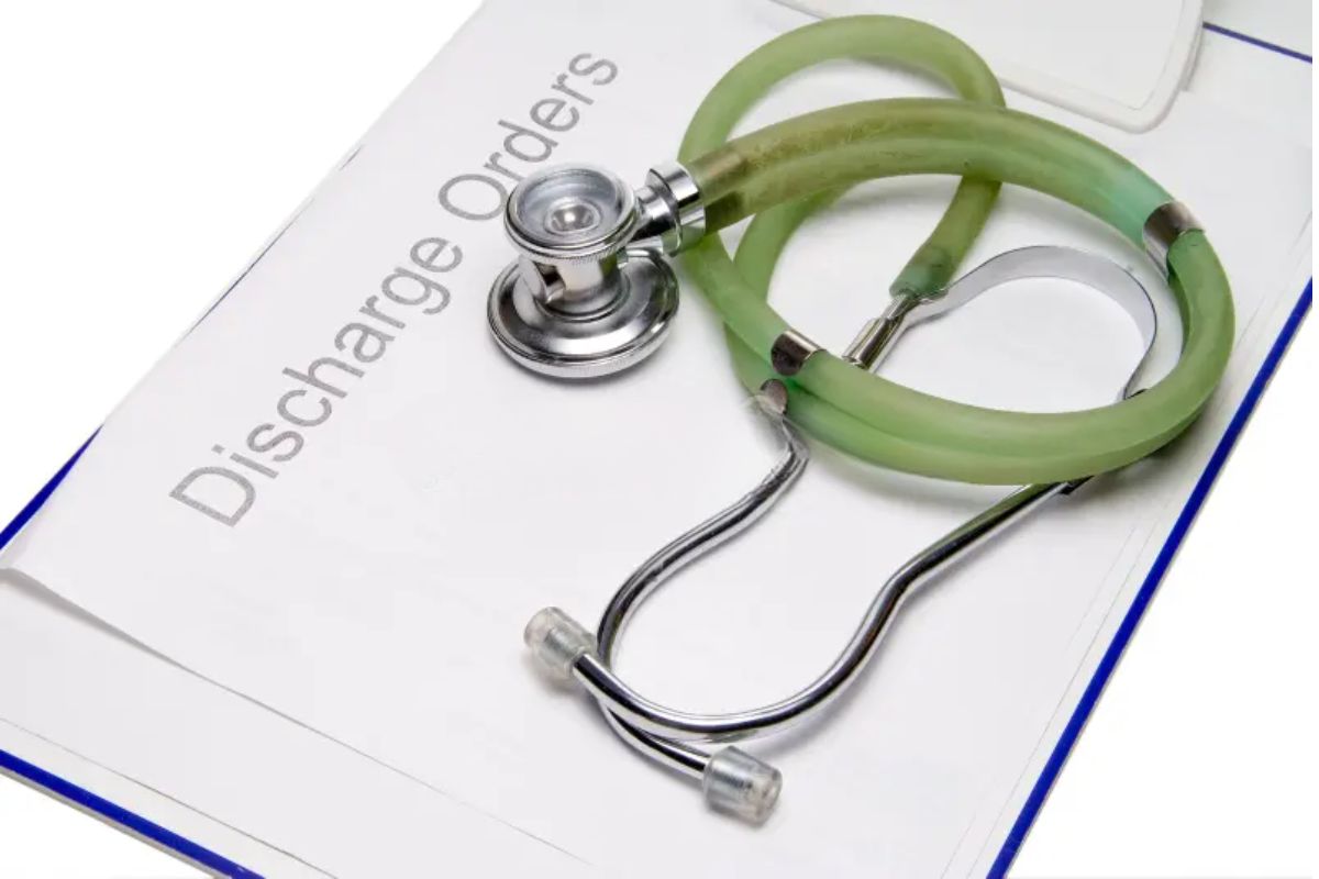 A stethoscope resting on an open book labeled “Discharge Orders,” symbolizing hospital discharge and patient care.